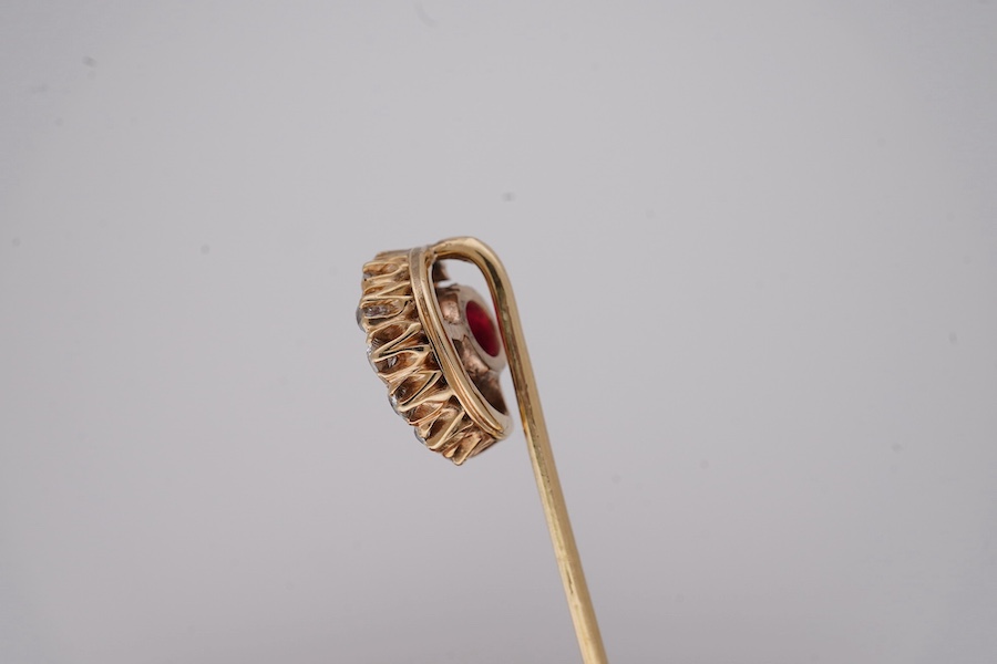 An early to mid 20th century yellow metal and single stone garnet topped doublet set stick pin, with diamond set crescent border, 61mm, gross weight 2.9 grams. Condition - fair to good